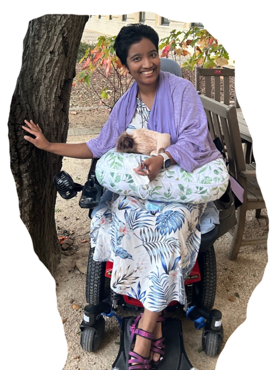 Harshini Busireddy smiling outdoors in her wheelchair.